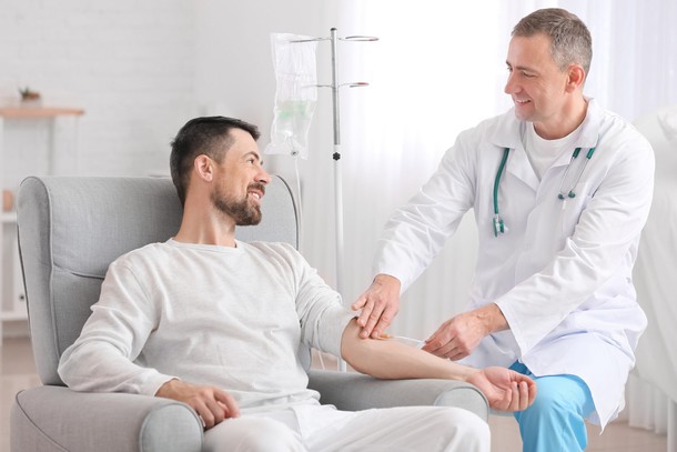 Doctor and man undergoing course of chemotherapy in clinic.