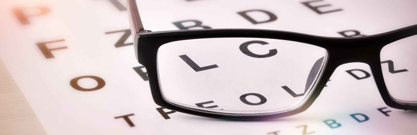 Glasses sitting atop an eye test chart