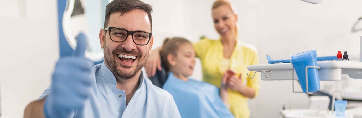 dentist giving a thumbs up and patient in his chair