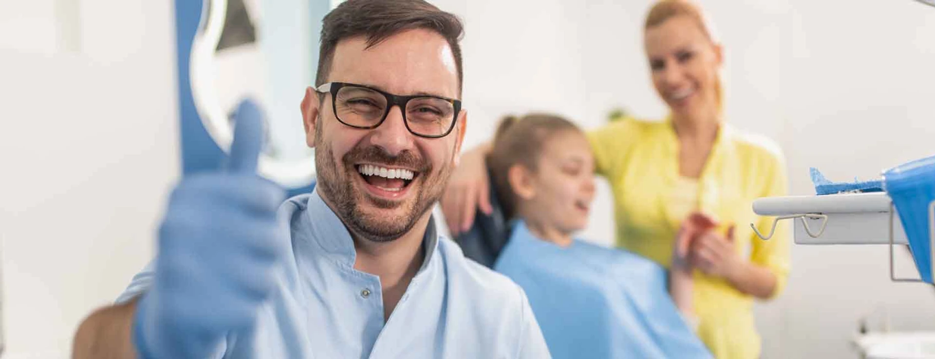 dentist giving a thumbs up and patient in his chair