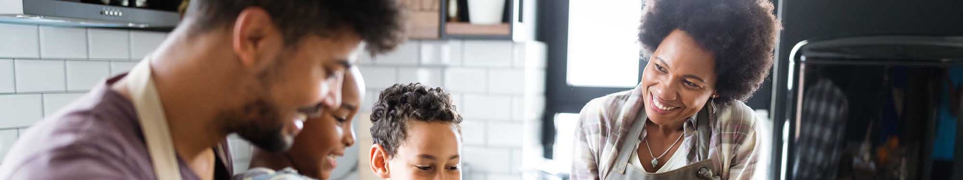 family of four prepares food together