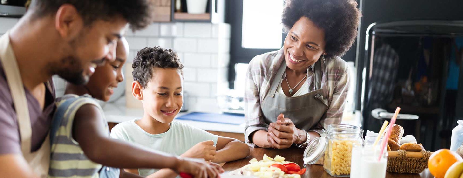 family of four prepares food together