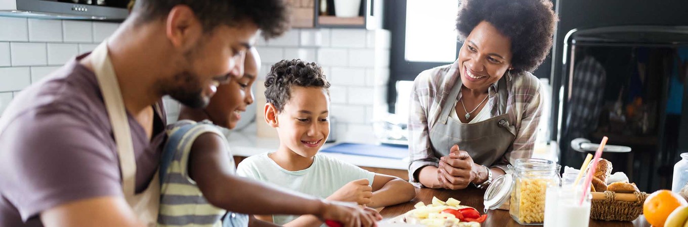 family of four prepares food together