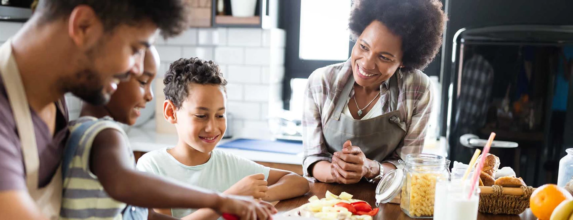 family of four prepares food together